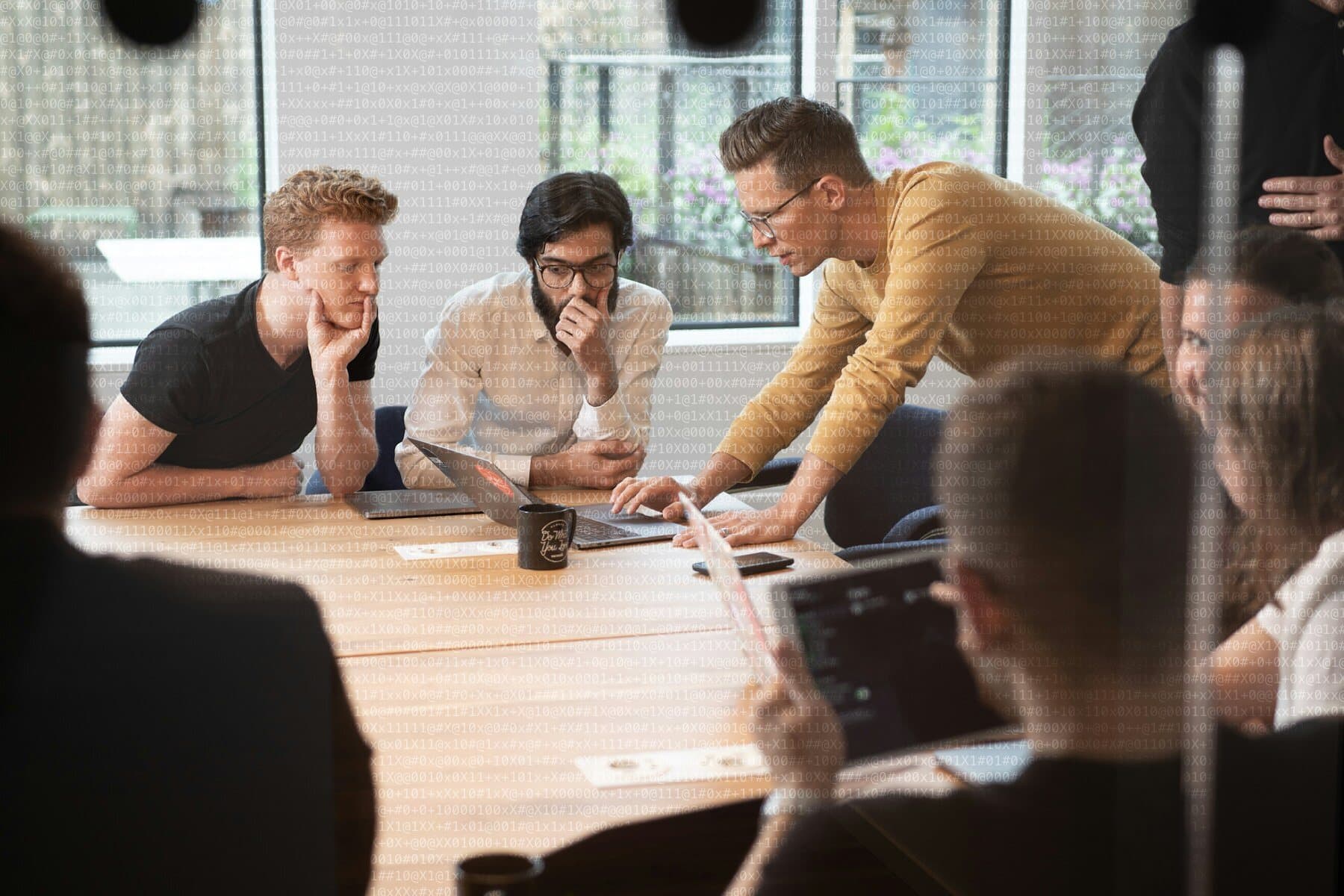 Equipo inclinado sobre una mesa revisando un prototipo juntos
